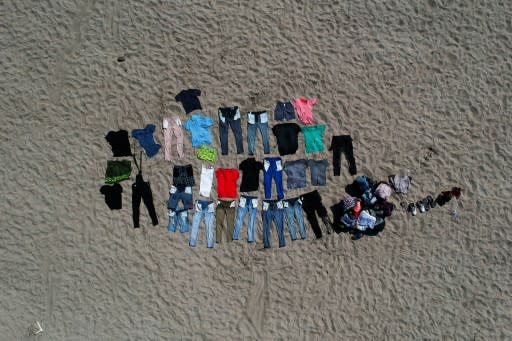 Honduran migrants travelling in a US-bound caravan rest and dry their clothes after crossing the Suchiate river into Mexico from Guatemala