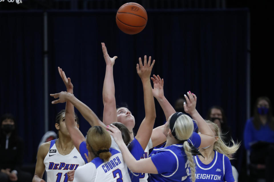 DePaul forward Jorie Allen, center, reaches for a loose ball during the first half of an NCAA college basketball game against Creighton, Saturday, Feb. 20, 2021, in Chicago. (AP Photo/Shafkat Anowar)