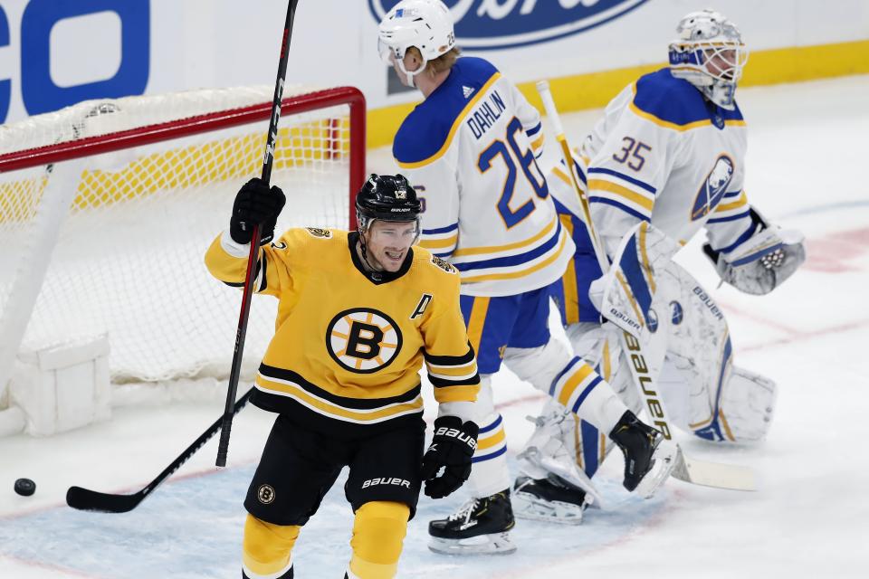 Boston Bruins' Charlie Coyle (13) celebrates the goal by Matt Grzelcyk on Buffalo Sabres' Linus Ullmark (35) during the second period of an NHL hockey game, Saturday, March 27, 2021, in Boston. (AP Photo/Michael Dwyer)
