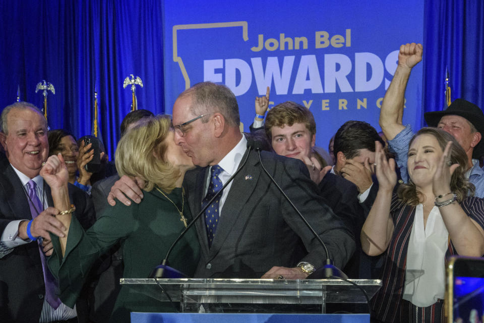 Louisiana Gov. John Bel Edwards celebrates with his wife Donna Edwards as he arrives to address supporters at his election night watch party in Baton Rouge, La., Saturday, Nov. 16, 2019. (AP Photo/Matthew Hinton)