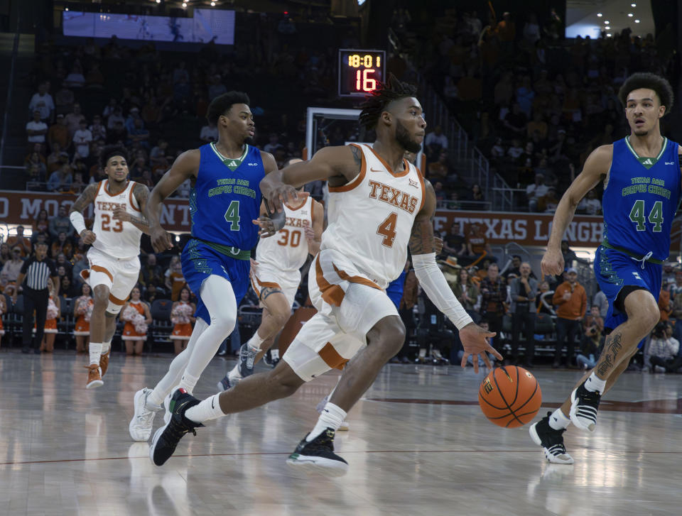 Texas guard Tyrese Hunter, center, drives the ball against Texas A&M Corpus Christi forward Dayne Prim (44) and guard Kam Parker, center left, during the first half of an NCAA college basketball game, Friday, Dec. 22, 2023, in Austin, Texas. (AP Photo/Michael Thomas)