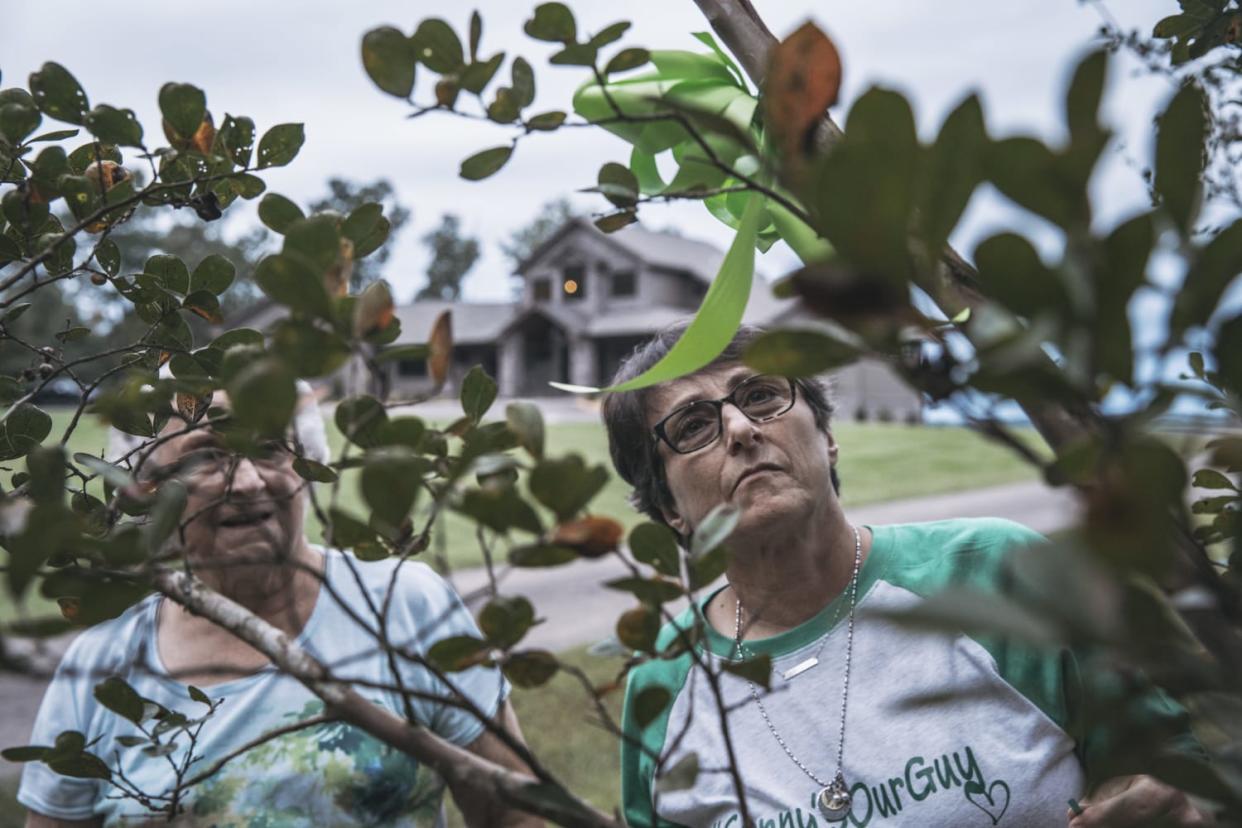 Image: Susan Melton and her mother Lura Dean Clayton hang green ribbons in remembrance of Sonny Melton