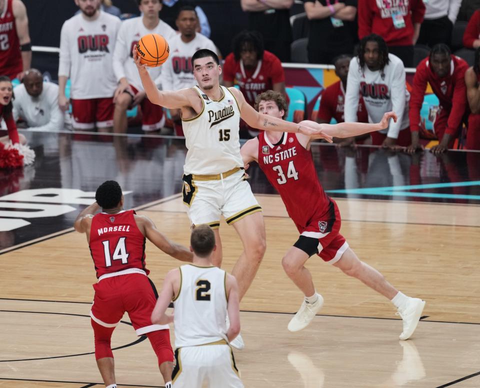 Zach Edey grabs the ball in front of North Carolina State's Ben Middlebrooks (34) during the Final Four of the 2024 men's NCAA Tournament at State Farm Stadium.