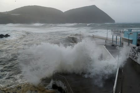 Waves crash on a wall at the port of Angra do Heroismo in Azores
