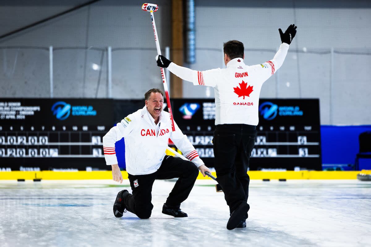 Paul Flemming, left, and Martin Gavin celebrate their win Saturday at the world senior men's curling championship in Sweden. (Raleigh Emerson/World Curling - image credit)