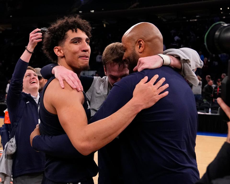 Mar 31, 2022; New York, New York, USA; Xavier Musketeers guard Colby Jones (3) and Xavier Musketeers guard Adam Kunkel (5) hug Xavier Musketeers interim head coach Jonas Hayes after the NIT college basketball finals against the Texas A&M Aggies at Madison Square Garden.