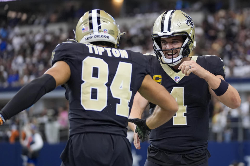 New Orleans Saints wide receiver Mason Tipton (84) and quarterback Derek Carr (4) react after a touchdown run by teammate Alvin Kamara during the first half of an NFL football game against the Dallas Cowboys, Sunday, Sept. 15, 2024, in Arlington, Texas. (AP Photo/Tony Gutierrez)