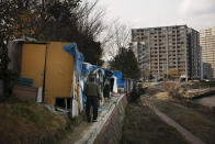 In this Tuesday, Jan. 14, 2020, photo, a homeless man walks to his shack at a homeless camp set up along the Tama River, in Kawasaki, west of Tokyo. Like the U.S., Japan has a relatively high poverty rate for a wealthy nation. It also is less generous with social welfare than countries in Europe, and lacks the sorts of private charities prevalent in the U.S. (AP Photo/Jae C. Hong)