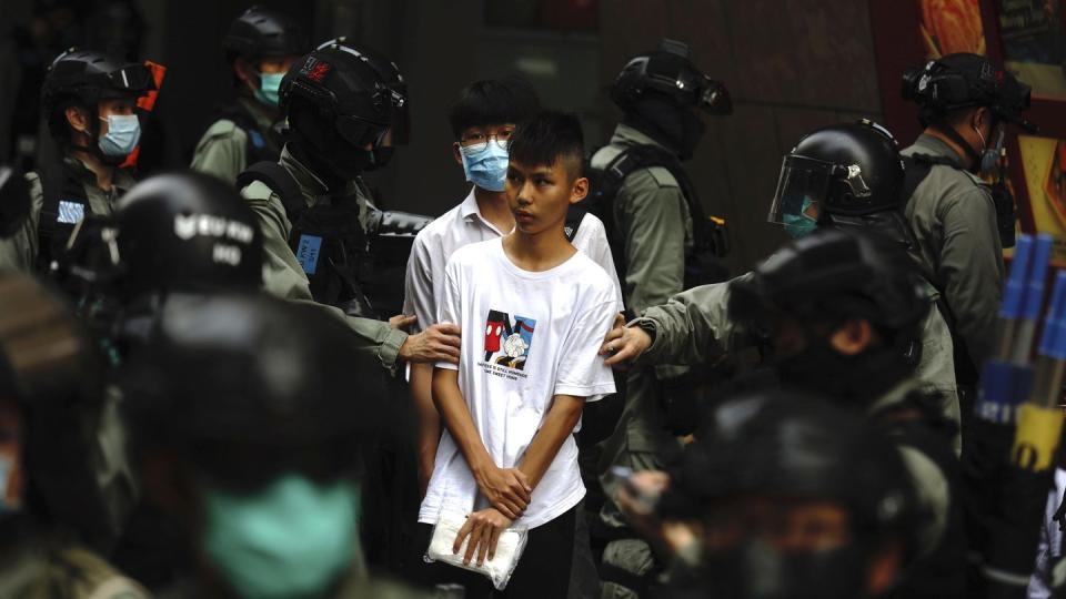 Bereitschaftspolizisten halten im Zentrum von Hongkong zwei junge Demonstranten fest.