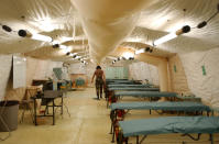 A U.S. soldier cleans the floor of a field hospital ward for Al Qaeda and Taliban detainees at Camp X-Ray February 7, 2002 in Guantanamo Bay, Cuba. Dozens of prisoners have been treated at the field hospital, some for pre-existing conditions. An amputation took place February 7. (Photo by Chris Hondros/Getty Images)