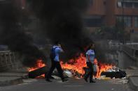 Cerca de la autopista que une Caracas con los acomodados suburbios del este, grupos de manifestantes erigían barricadas para cortar carreteras. Pero cuando llegaba la policía a desarmarlas, corrían a montar los cortes en otros sitios. REUTERS/Tomas Bravo