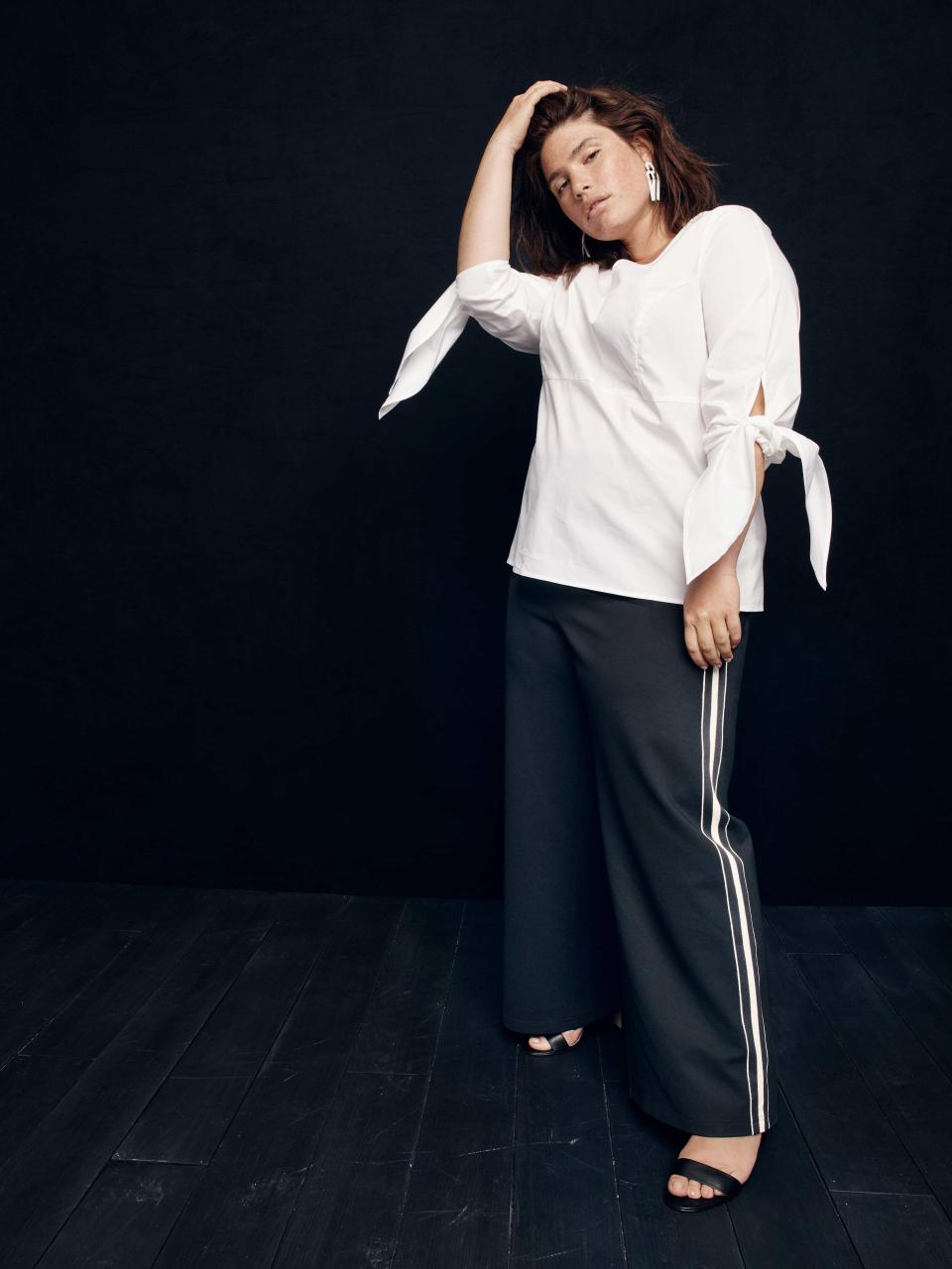 Model wears white blouse and racer stripe trousers from the new size-inclusive J.Crew collection with Universal Standard. (Photo: Courtesy of J.Crew)