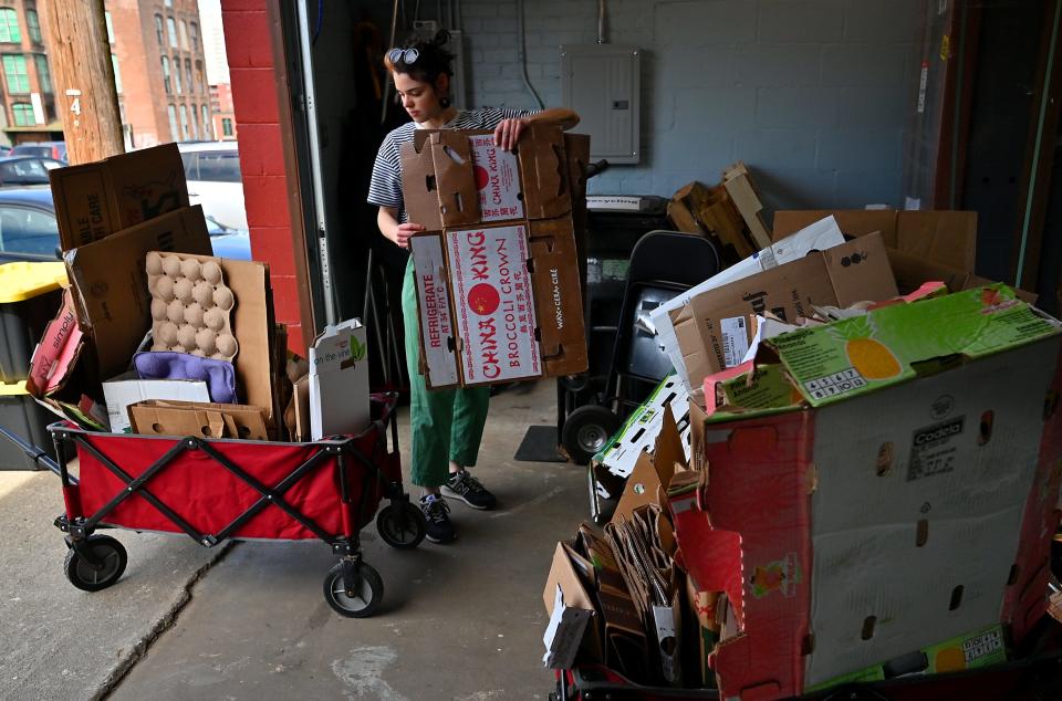 Madeline Lawrence breaks up cardboard boxes to recycle at a previous Regional Environmental Council Earth Day cleanup in Worcester.