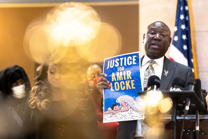 Civil rights attorney Ben Crump holds a sign reading: Justice for Amir Locke. 
