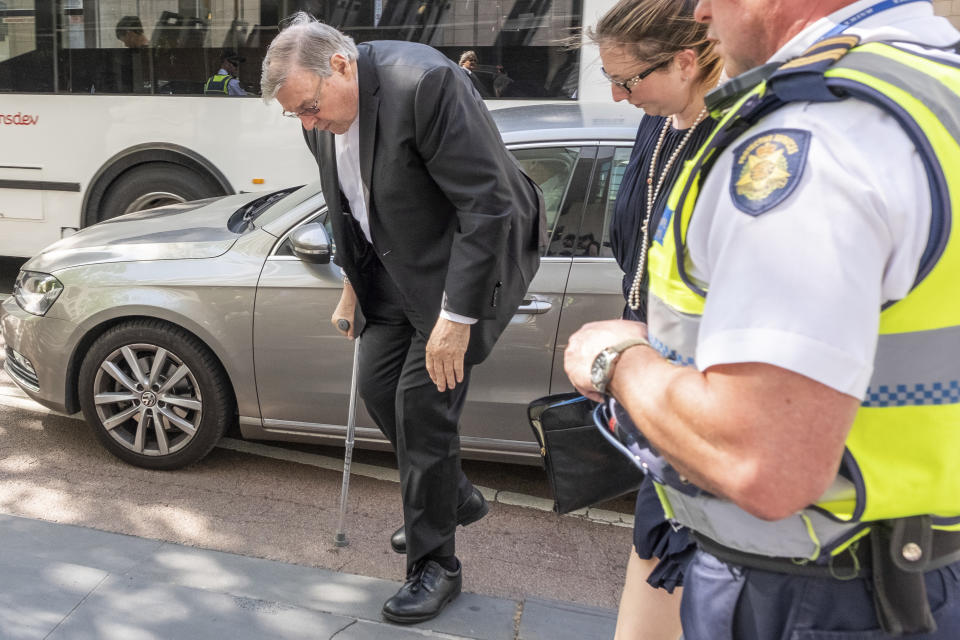 In this Dec 7, 2018, photo, Cardinal George Pell, the most senior Catholic cleric to face sex charges, steps out of a car using walking crutches as he arrives at an Australian court. Pell was sentenced in an Australian court on Wednesday, March 13, 2019 to 6 years in prison for molesting two choirboys in a Melbourne cathedral more than 20 years ago. (AP Photo/Asanka Brendon Ratnayake)