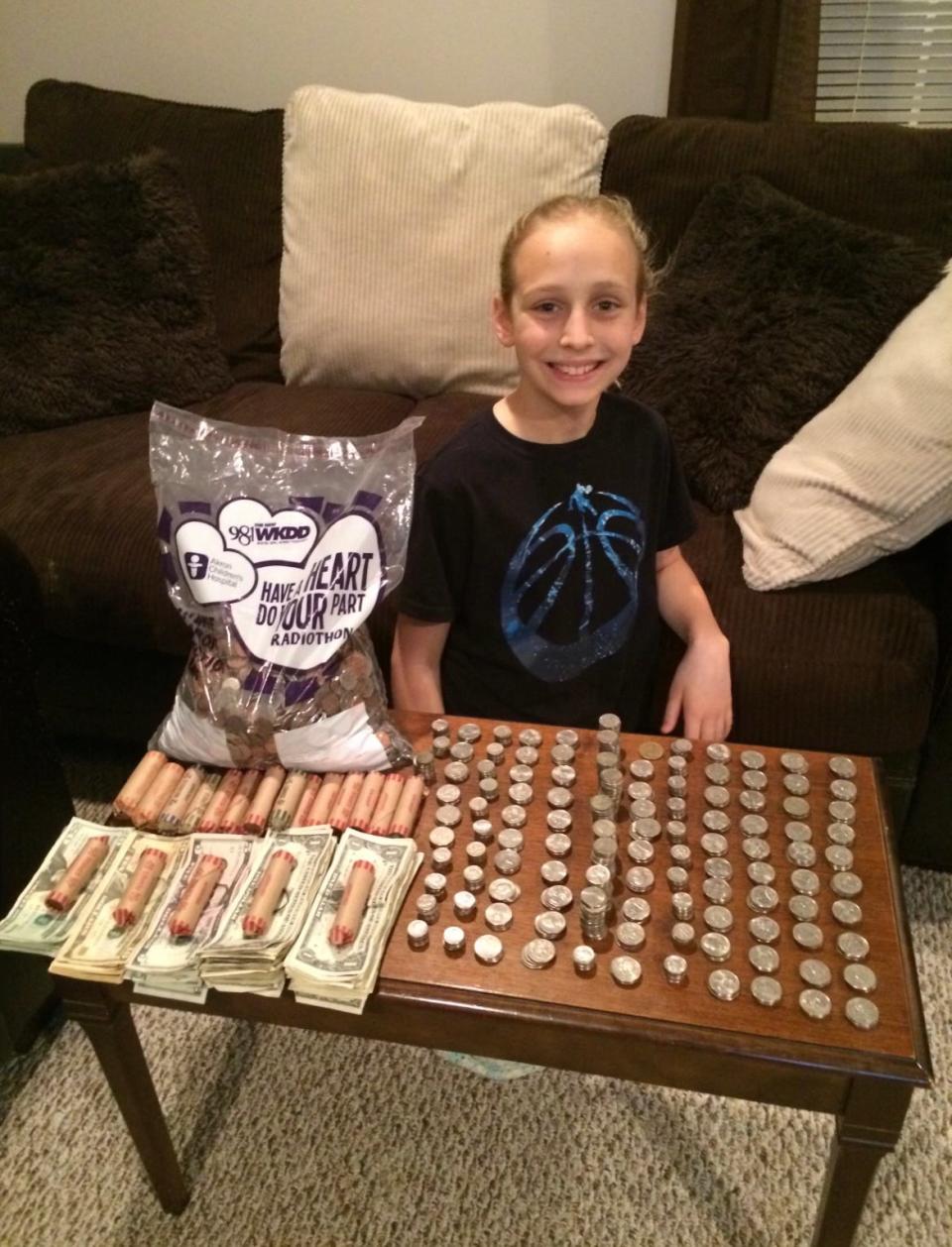 Kenslee Brandon counts some of the $800 she collected from individuals to donate to Akron Children's Hospital during a fundraising campaign. She was treated at the hospital for Type I diabetes.