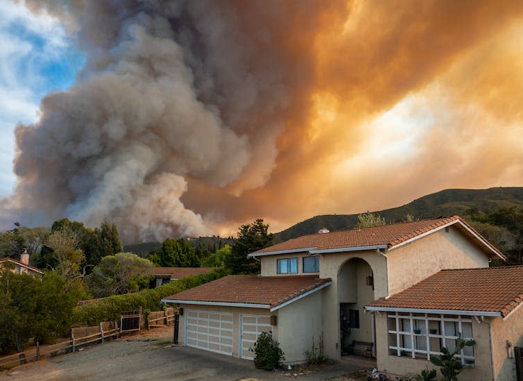 Suburban house with large fire in background