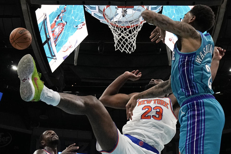 New York Knicks center Mitchell Robinson blocks a shot by Charlotte Hornets forward P.J. Washington during the first half of an NBA basketball game on Saturday, Nov. 18, 2023, in Charlotte, N.C. (AP Photo/Chris Carlson)