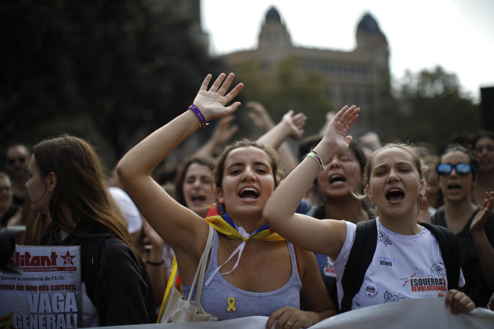 People, some wearing yellow ribbons in support of jailed pro-independence politicians, protest in Barcelona, Spain, Monday, Oct. 14, 2019. Spain's Supreme Court on Monday convicted 12 former Catalan politicians and activists for their roles in a secession bid in 2017, a ruling that immediately inflamed independence supporters in the wealthy northeastern region. Poster reads in Catalan, General Strike. (AP Photo/Emilio Morenatti)