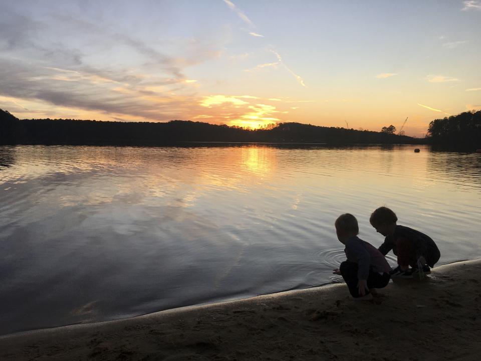 This image provided by Lucy O'Donoghue shows a children playing by a lake. Although this year's quarantine limited Lucy O'Donoghue's opportunities for travel, she found ways to focus on her two sons by taking them for 'micro-holidays' at a beach near their Georgia home. (Lucy O'Donoghue via AP)