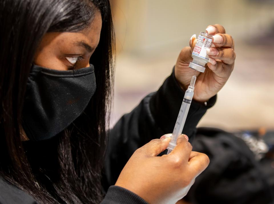 Eriya Daniel, traveling nurse from Dayton, prepares Moderna COVID-19 vaccines to be given to 500 staff members from the Middletown School District. Liz Dufour/The Enquirer