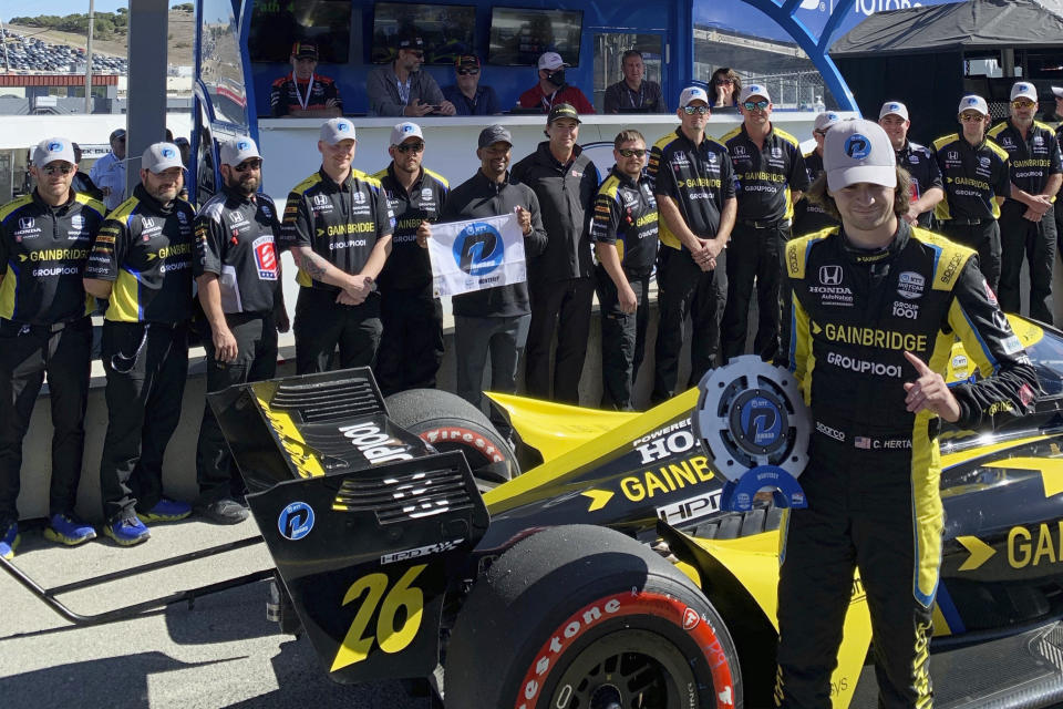 Colton Herta poses with his Andretti Autosport team after winning the pole, Saturday, Sept. 18, 2021, at Laguna Seca Raceway in Monterey, Calif. Herta is the defending race winner from 2019. (AP Photo/Jenna Fryer)