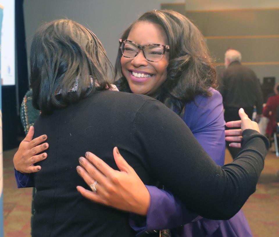 Congresswoman Emilia Sykes gets a hug from Akron Public Schools Assistant Superintendent Tamea Caver before speaking to a packed house at the Akron Roundtable on Friday at the John S. Knight Center in Akron.