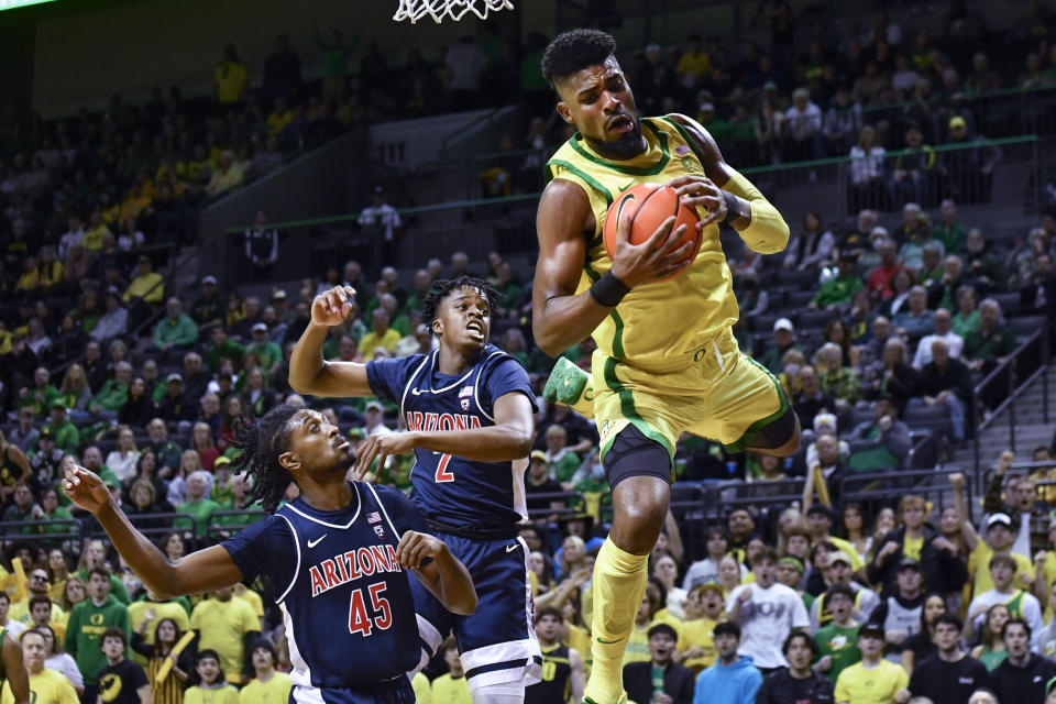 Oregon forward Quincy Guerrier (13) tries to haul in a rebound next to Arizona guards Cedric Henderson Jr. (45) and Adama Bal (2) during the first half of an NCAA college basketball game Saturday, Jan. 14, 2023, in Eugene, Ore. (AP Photo/Andy Nelson)