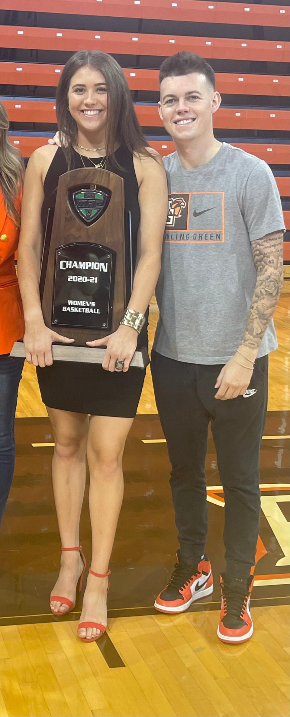 Kenzie Lewis, left, with her brother Riley, holding the 2020-21 MAC basketball championship trophy, which she won as a member of Bowling Green's team.