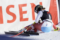 Switzerland's Lara Gut Behrami sits on the snow after crossing the finish line of an alpine ski, women's World Cup super-G, in Lenzerheide, Switzerland, Saturday, March 5, 2022. (AP Photo/Giovanni Auletta)