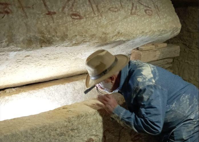 Renowned Egyptian archaeologist Dr. Zahi Hawass peers into a sarcophagus found at the bottom of a deep vertical shaft in Saqqara, near Cairo, in a photo shared with CBS News on January 26, 2023, by Ali Abu Desheesh, one of the archaeologists on Hawass' team.  / Credit: Courtesy of Ali Abu Desheesh