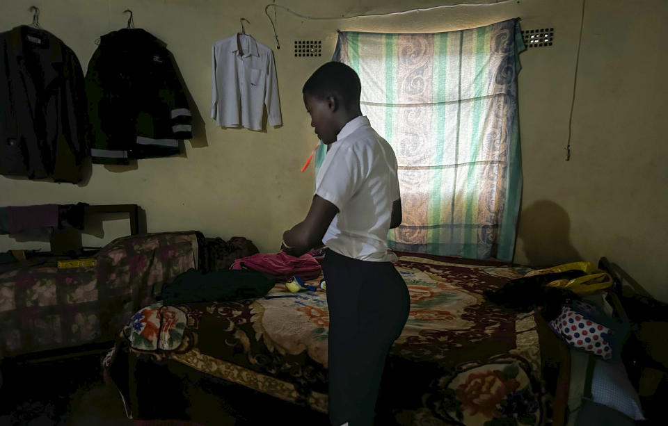 Luyanda Hlali gets ready at dawn for her 2 hour-long walk from the village of Stratford to her school in Dundee, South Africa, Thursday, Oct. 26, 2023. Thousands of children in South Africa's poorest and most remote rural communities still face a miles-long walk to school, nearly 30 years after the country ushered in democratic change. (AP Photo/ Mogomotsi Magome)