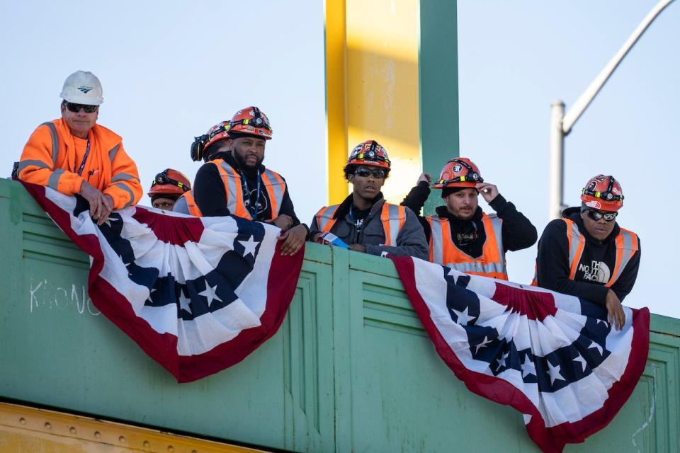 Rail workers look on from atop a bridge before the arrival of U.S. President Joe Biden to speak at the Baltimore and Potomac (B&P) Tunnel North Portal on January 30, 2023 in Baltimore, Maryland.