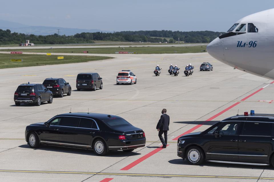 The limousine carrying Russian president Vladimir Putin, bottom left, next to Putin's Iljuschin Il-96 airplane, leaves the airport in a motorcade ahead of the US - Russia summit (EPA)