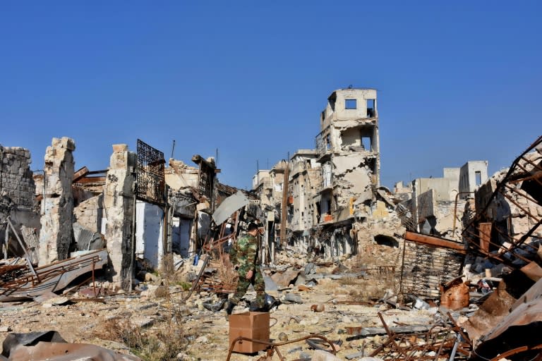 A Syrian pro-government fighter walks amidst the rubble in old Aleppo's Jdeideh neighbourhood