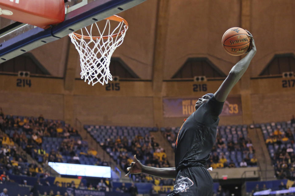 Oklahoma State forward Yor Anei (14) goes to the basket during the first half of the team's NCAA college basketball game against West Virginia Tuesday, Feb. 18, 2020, in Morgantown, W.Va. (AP Photo/Kathleen Batten)