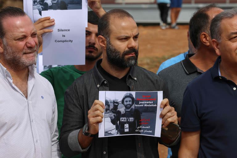 Personas levantan retratos del periodista Issam Abdallah, quien fue asesinado el 13 de octubre por un bombardeo en Líbano, durante una protesta frente a la sede de las Naciones Unidas en el centro de Beirut el 15 de octubre de 2023.