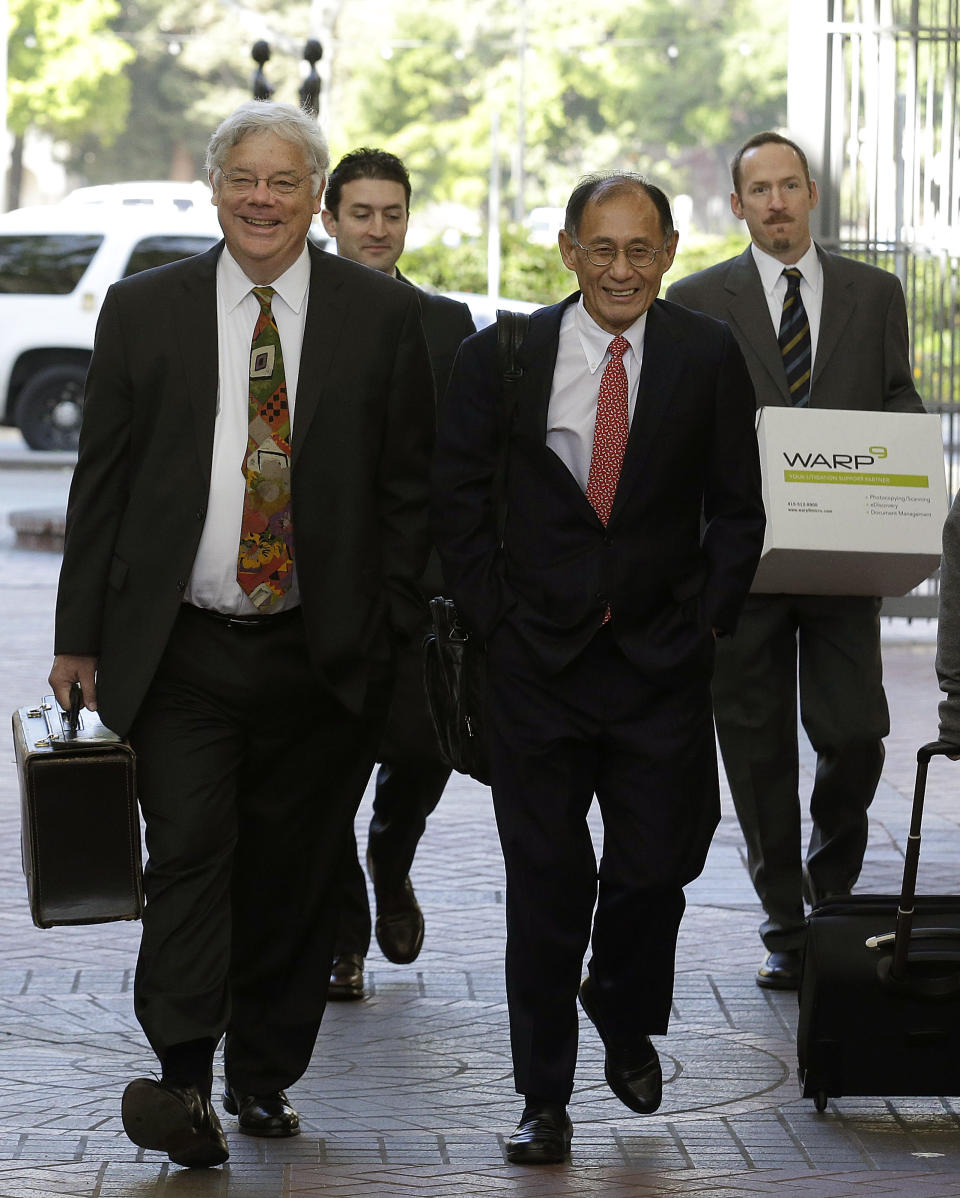 Apple attorneys Harold McElhinny, left, and William Lee, walk with others to a federal courthouse in San Jose, Calif., Monday, April 28, 2014. Dueling expert witnesses were called back to the stand Monday in a San Jose federal courtroom to discuss whether the ruling in a legal dispute between Apple and Motorola has any effect on the Apple and Samsung trial. (AP Photo/Jeff Chiu)