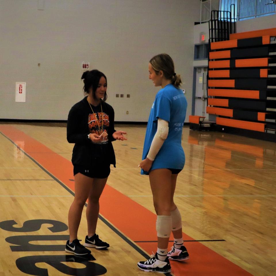 Solon volleyball coach Mikayla Long gives a player tips during practice. The former Spartans player has returned to lead the team this season.