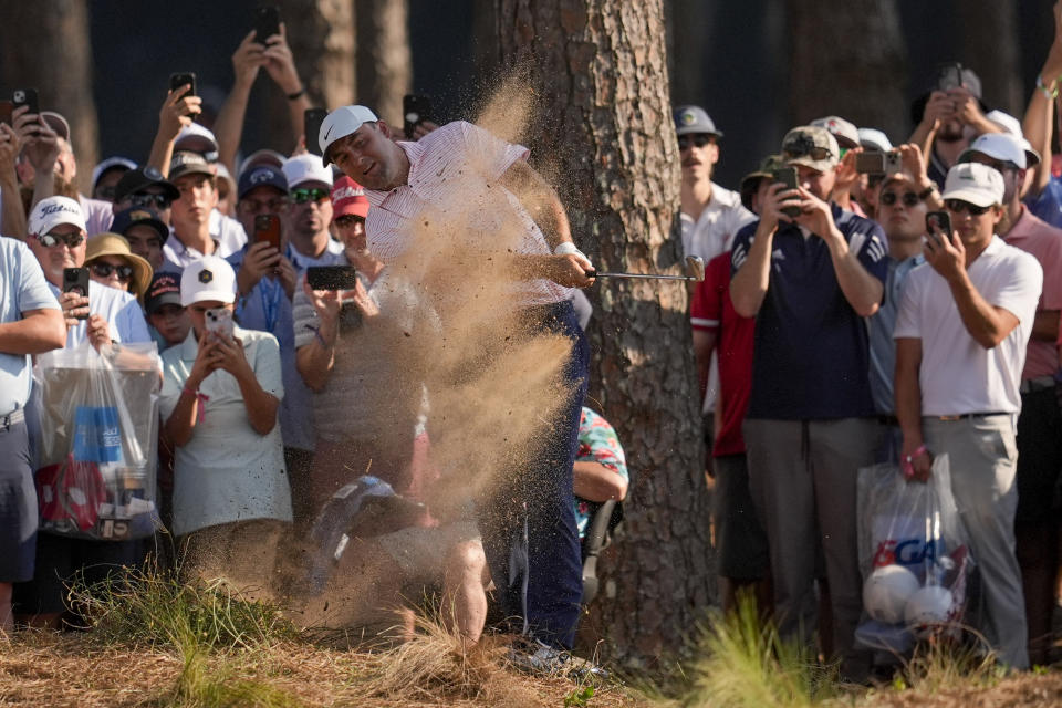 Scottie Scheffler hits from the pine straw on the 15th hole during the first round of the U.S. Open golf tournament Thursday, June 13, 2024, in Pinehurst, N.C. (AP Photo/Mike Stewart)