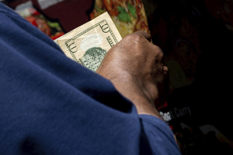 FILE - A person pays at a Halal food truck, Wednesday, July 13, 2022, in New York. Consumers have proven resilient through the ups and downs of the COVID economy. Their spending has driven a strong recovery -- and ignited inflationary pressures. (AP Photo/Julia Nikhinson, File)