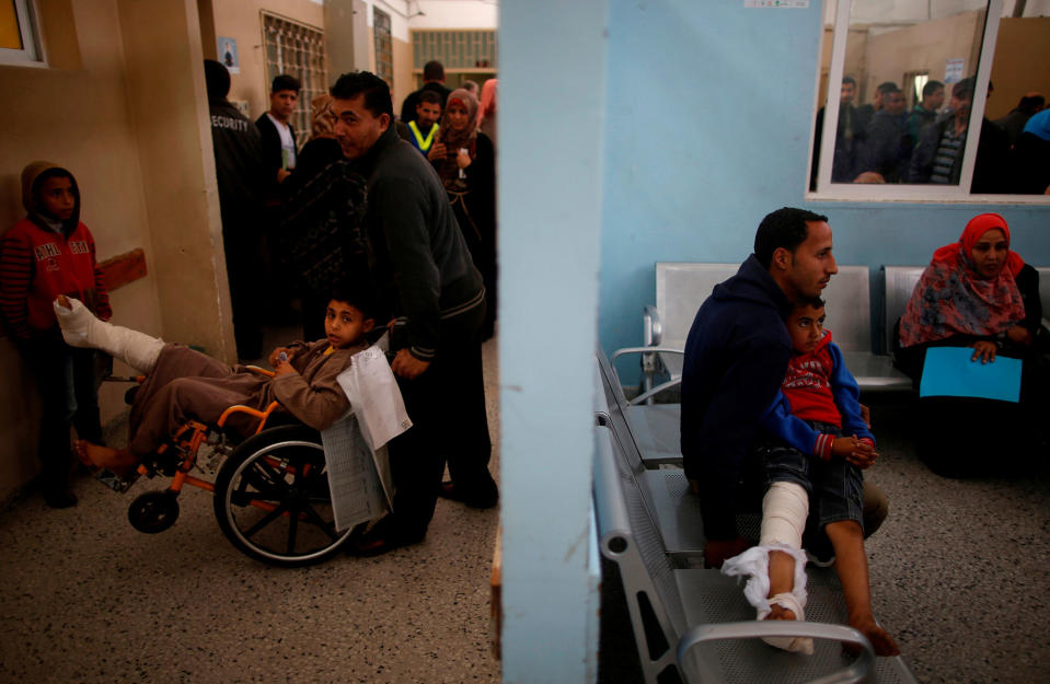 <p>Palestinian boy Mohammed Bahtiti (L), 13, who fractured his leg, waits for medical checks at an outpatient clinic at Shifa hospital, Gaza’s largest public medical facility, in Gaza City, March 29, 2017. (Photo: Mohammed Salem/Reuters) </p>