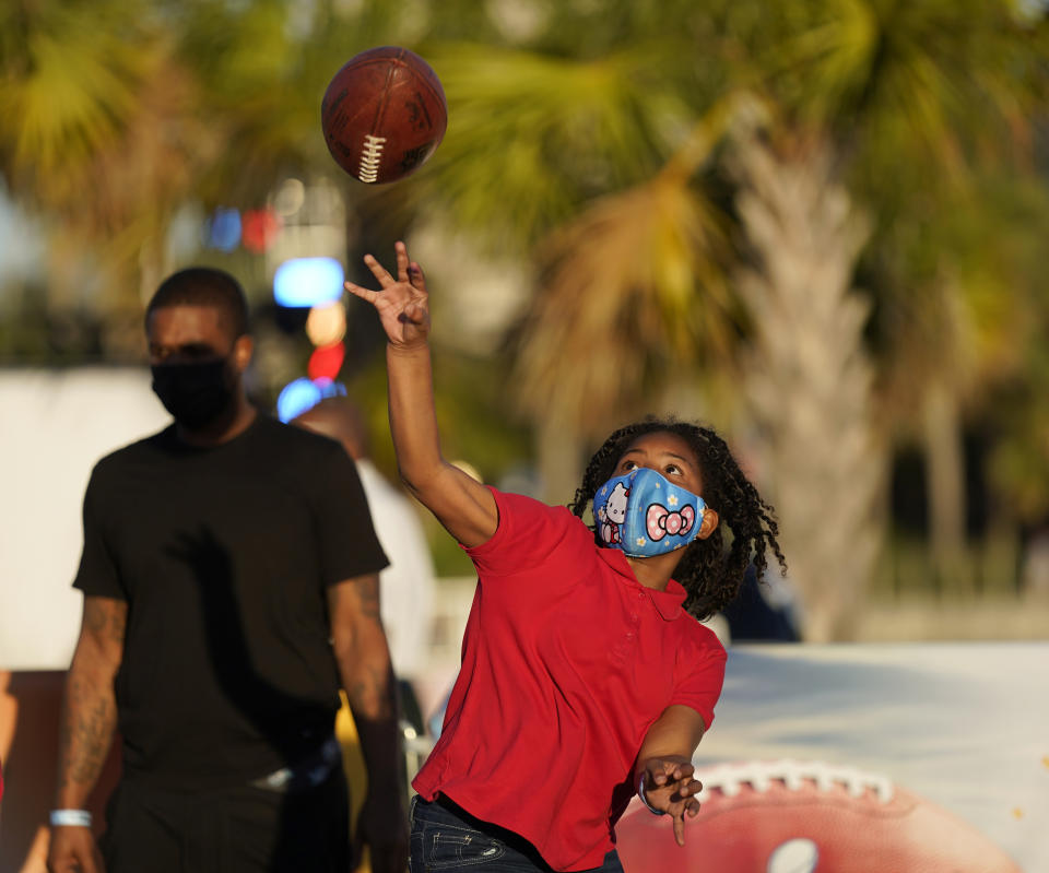 Anaja Brackett throws a football at the NFL Experience for Super Bowl LV Friday, Jan. 29, 2021, in Tampa, Fla. (AP Photo/David J. Phillip)