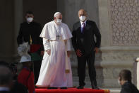 Pope Francis is welcomed by Iraqi President Barham Salih, at Baghdad's Presidential Palace, Iraq, Friday, March 5, 2021. Pope Francis has arrived in Iraq to urge the country's dwindling number of Christians to stay put and help rebuild the country after years of war and persecution, brushing aside the coronavirus pandemic and security concerns. (AP Photo/Andrew Medichini)