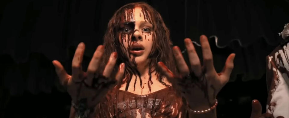 Young woman with blood on face and hands, expressing shock