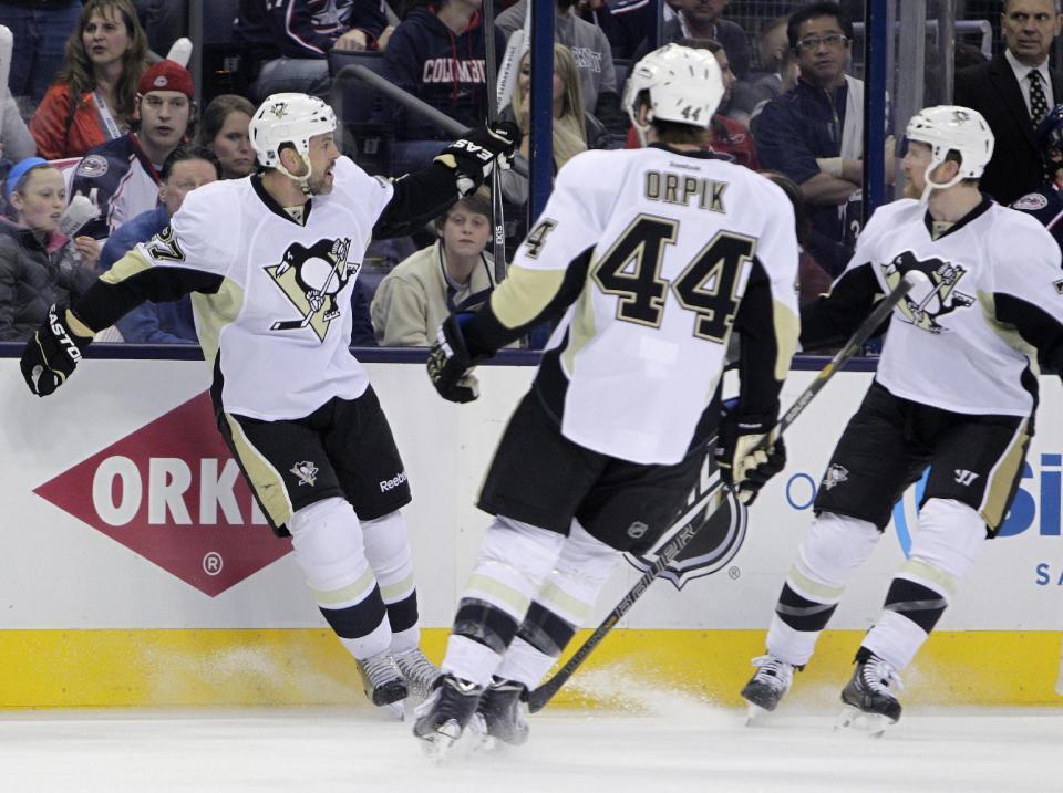 Pittsburgh Penguins' Craig Adams, left, of Brunei, celebrates his goal against the Columbus Blue Jackets with teammates Brooks Orpik, center, and Paul Martin during the first period of Game 4 of a first-round NHL hockey playoff series on Wednesday, April 23, 2014, in Columbus, Ohio. (AP Photo/Jay LaPrete)