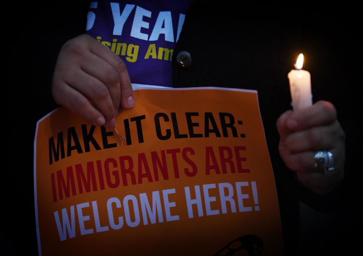 Migrant rights groups hold candles during a vigil to protest against US President Donald Trump's new crackdown on 'sanctuary cities', outside the City Hall in Los Angeles: MARK RALSTON/AFP/Getty Images