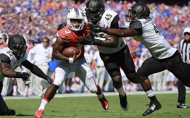 Minnesota Vikings' and former Vanderbilt Commodores linebacker, Stephen Weatherly, tackles Florida Gators quarterback Treon Harris.