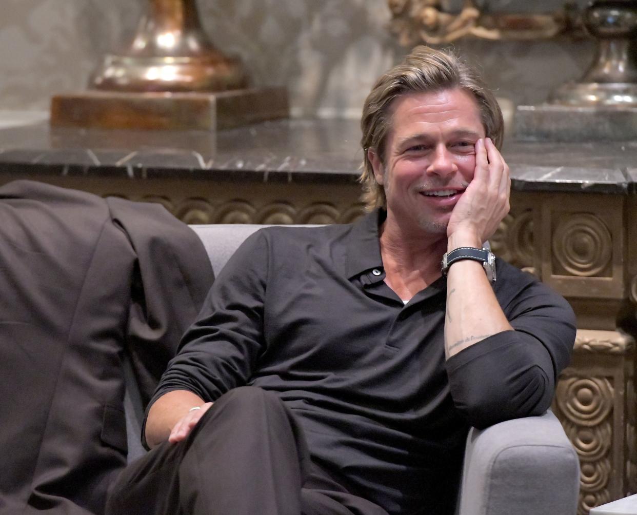 Brad Pitt sitting and smiling