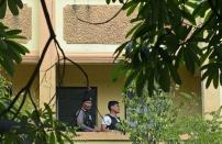 Policemen stand on a balcony at the compound where they detained a suspect in the August 17 shrine bombing in a Bangkok suburb on August 29, 2015